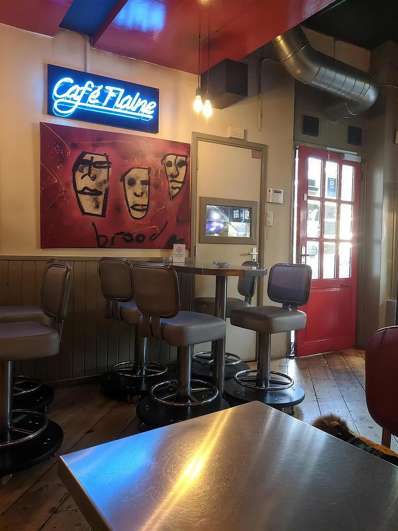 Binnen bij Empire: barkrukken, een neonbord en kunst aan de muur